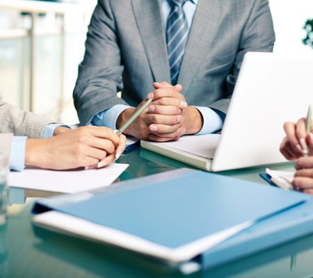 Close-up of hands of boss at workplace with laptop and hands of two females near by