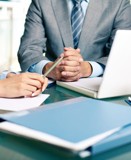 Close-up of hands of boss at workplace with laptop and hands of two females near by